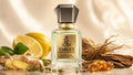 A bottle of Target Royal Essence perfume stands centered on a reflective surface, surrounded by lemons, ginger root, dried herbs, and amber crystals against a warm draped fabric background.